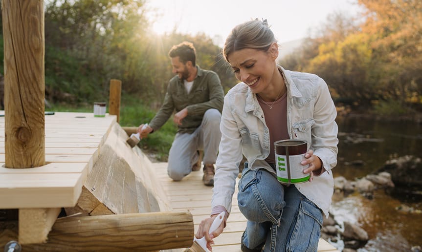 A man and woman painting outside.