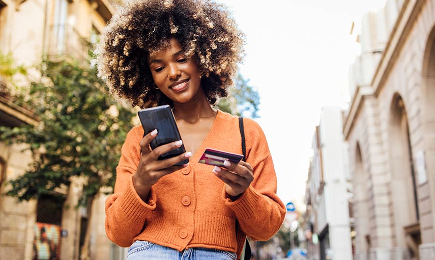A women looking at her phone and card.