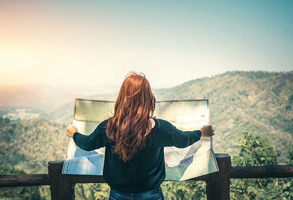 Woman holding blueprints overlooking mountains