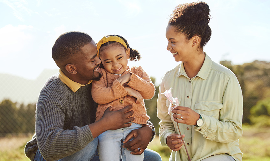 Mother and father smiling at child.
