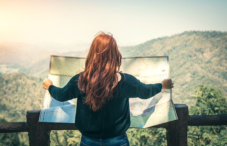 Woman holding blueprints overlooking mountains