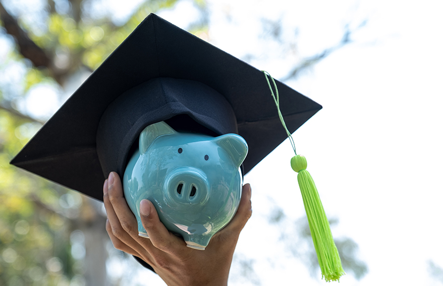 Piggy bank wearing graduation cap